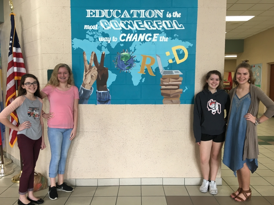 4 female students in front of mural